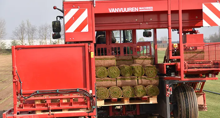 Remorque du tracteur des Gazonnières d'Alsace, transportant des rouleaux de gazon prêts à être livrés.
